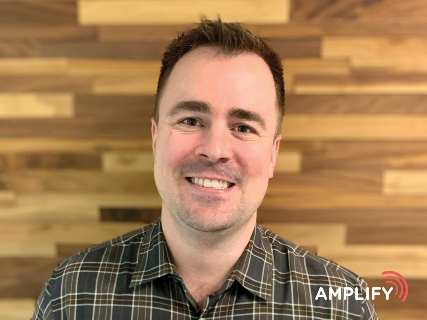 Photo of Luke Newman with Amplify Logo